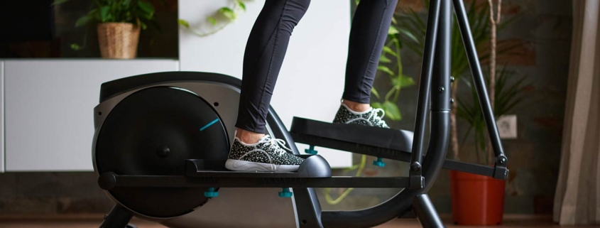 A womans legs training on smart elliptical trainer indoors at home in daylight with natural light