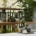 a balcony with various tropical plants, funriture, coffee and a beautiful nature view