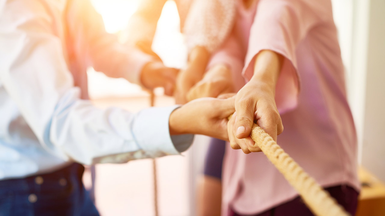 Team of coworker pulling rope together stock photo