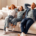 Cheerful family with child girl enjoying quality time at home in their living room, sitting on comfortable sofa, smiling and looking relaxed stock photo