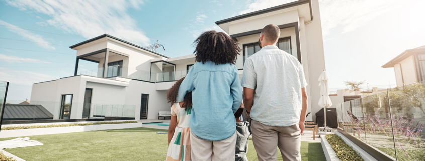 new house and family in their backyard together looking at their property